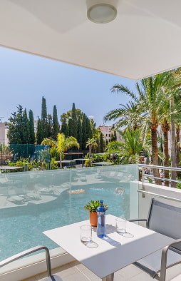 Apartment terrace overlooking the pool Terrace with table and chairs at a holiday apartment in Puerto Pollensa, overlooking the garden and pool