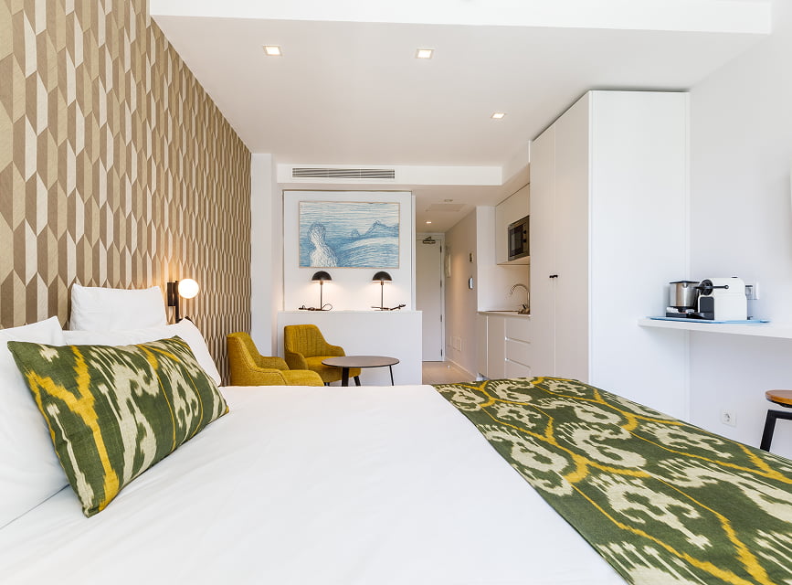Studio with equipped kitchen in Puerto Pollensa Double bed with Mallorcan bedspread, armchair corner and kitchen with coffee machine in a holiday studio