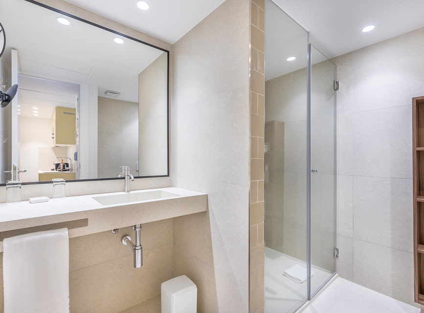 Studio bathroom with shower Studio bathroom with washbasin, large mirror and glass shower, at Illa d'Or Apartments