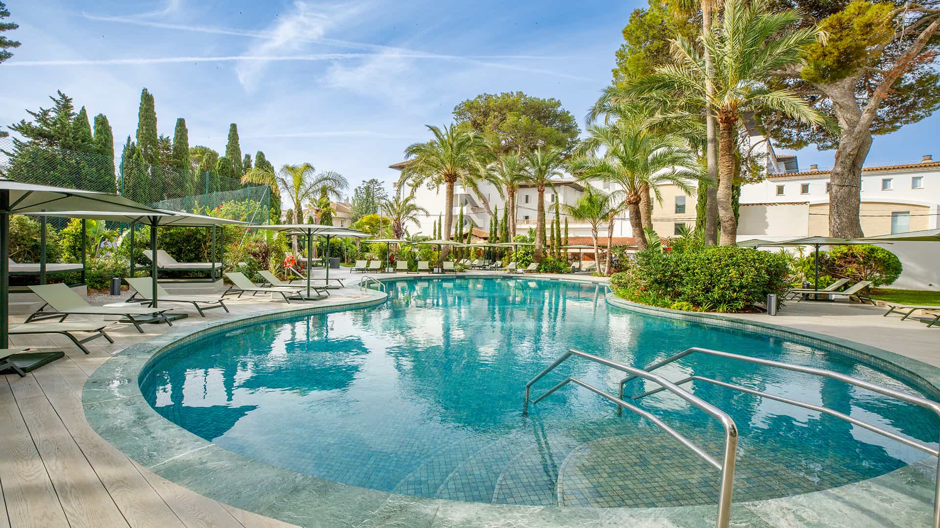 Illa d'Or Apartments pool in Puerto Pollensa Outdoor pool surrounded by palm trees and gardens at the Illa d'Or Apartments complex in Puerto Pollensa