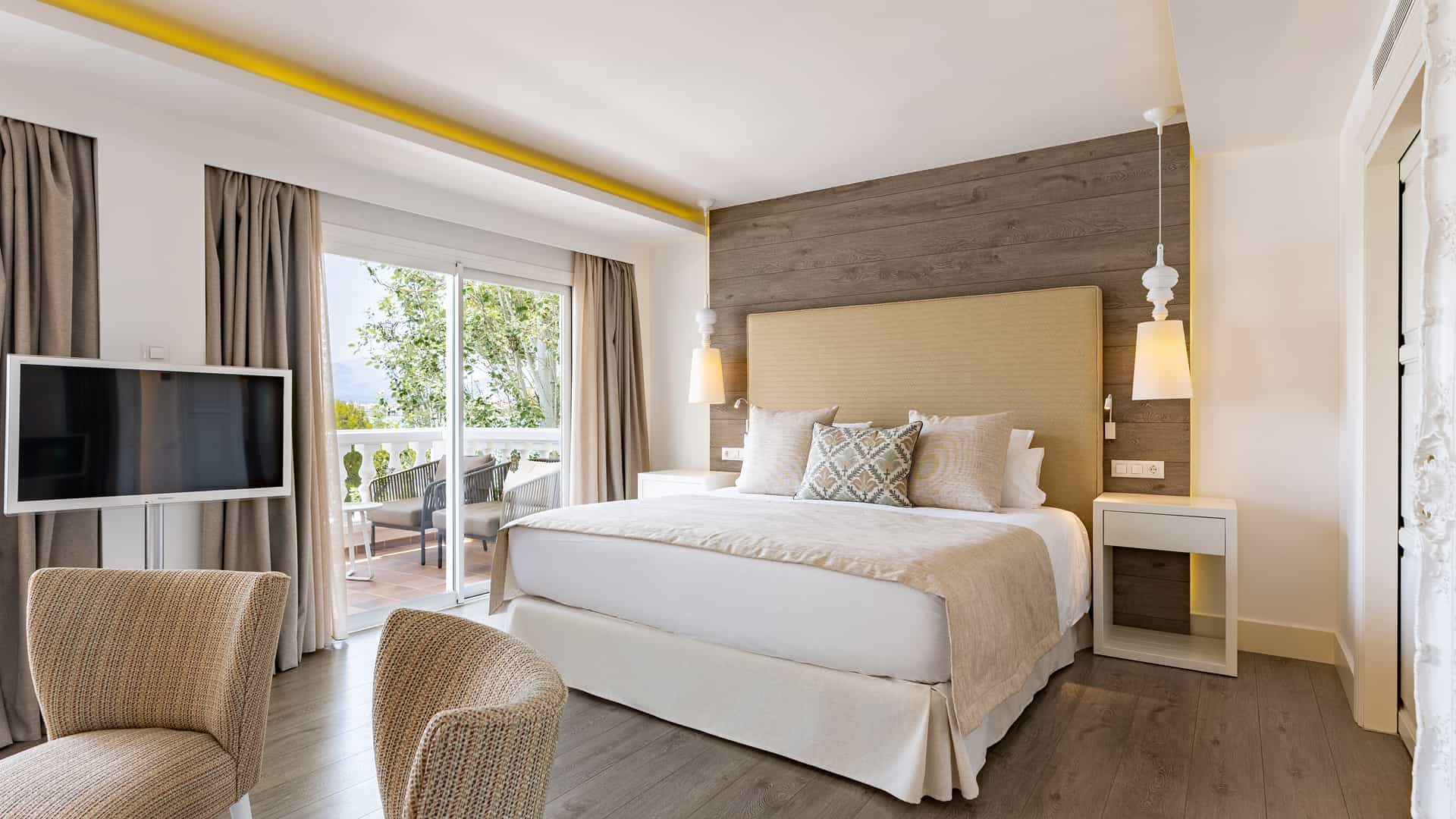 Double room with a double bed, armchairs and terrace access at Hotel Illa d'Or in Puerto Pollensa