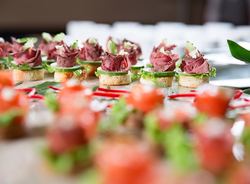 Roastbeef-Canapés auf Brot mit grünen Blättern, serviert bei einer Veranstaltung im Hotel Illa d'Or