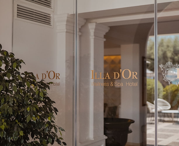 Glastüren mit dem Logo des Hotels, die in das Hotelgebäude führen.
