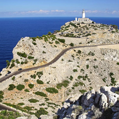 Kurvenreiche Straße zum Leuchtturm am Cap de Formentor über Klippen und tiefblauem Meer