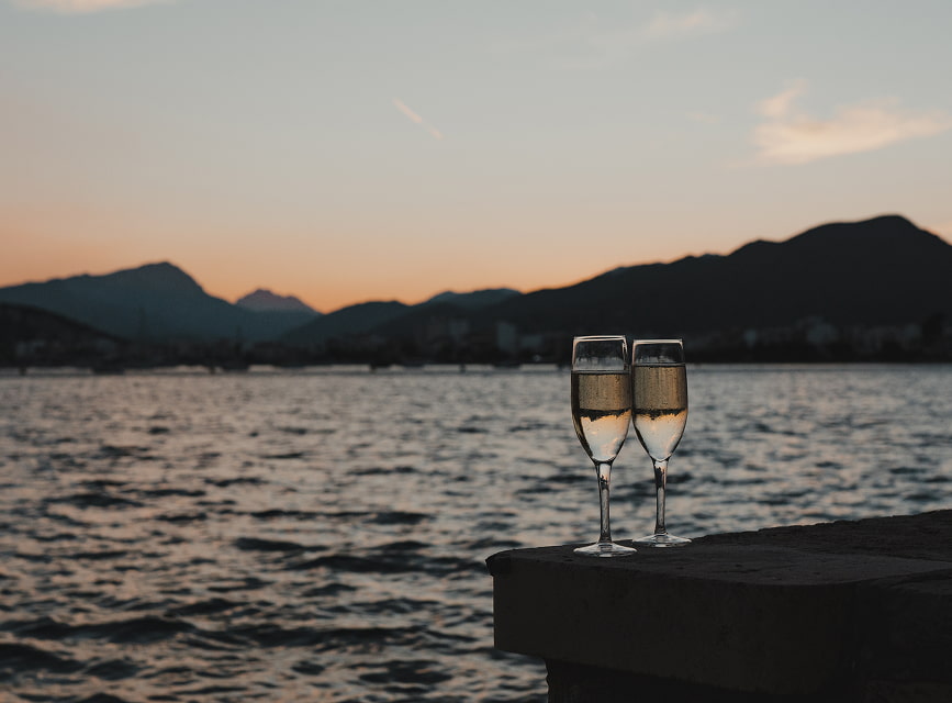 Indulgence at sunset by the sea Two glasses of sparkling wine by the sea at sunset, with Pollensa Bay and the mountains in the background