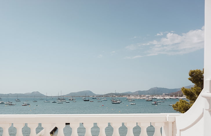 View from the room balcony over Pollensa Bay, with boats at anchor and mountains in the background