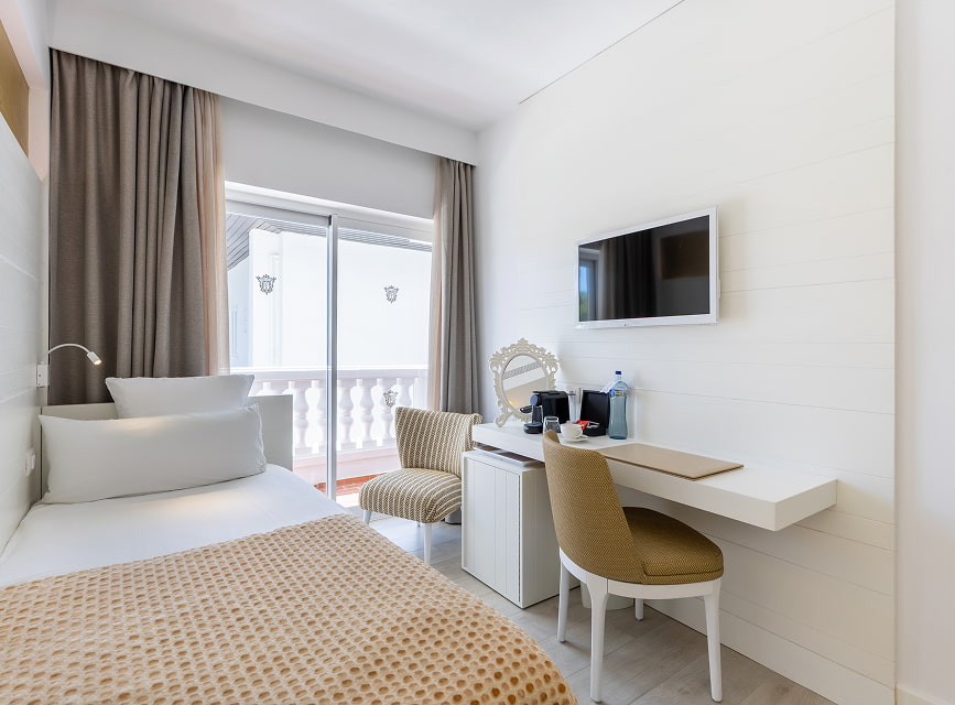 Room for one with a single bed, desk, minibar, TV and balcony access